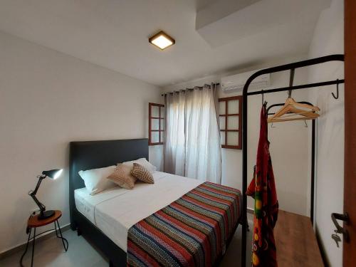 Un dormitorio con una cama con una colcha blanca. en Mamanguá - Apto c/ piscina, 50mts da praia, cozinha, churrasqueira, ar con, WiFi, netflix, garagem, en Paraty