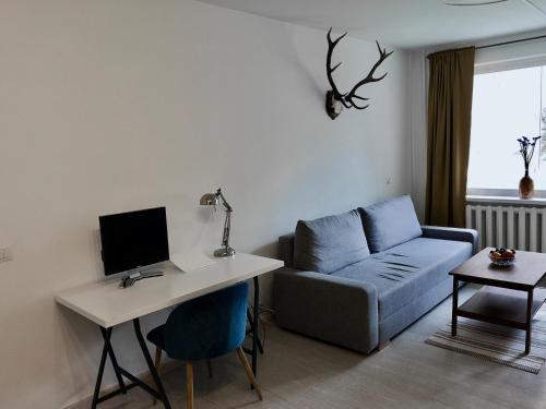 a living room with a couch and a desk with a computer at Homely apartment in Kėdainiai in Kėdainiai