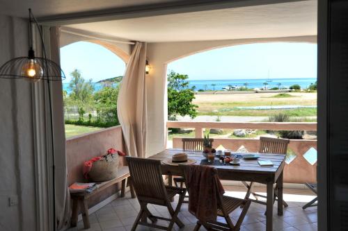 jadalnia ze stołem i widokiem na ocean w obiekcie Cala di Sole Lecci w mieście Porto-Vecchio