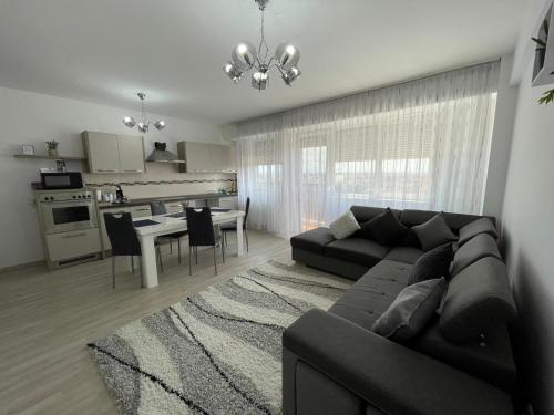 un soggiorno con divano nero e una cucina di Class DeLuxe Apartments a Oradea