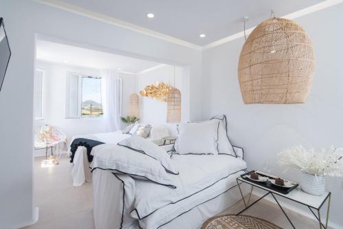 um quarto branco com uma cama e uma mesa em Divine Naxos Villa em Plaka