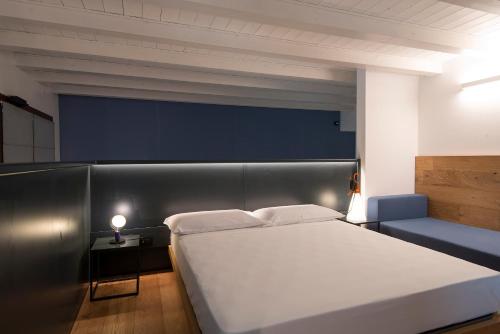 a bedroom with a large white bed and a blue couch at Agriturismo Le Grazie in Verona