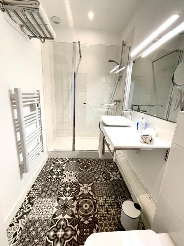 a bathroom with a shower and a black and white tile floor at Maison Dormoy in Marseille