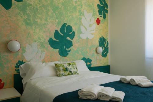 a bedroom with a bed with towels on it at Hotel Punto Verde in Marina di Campo