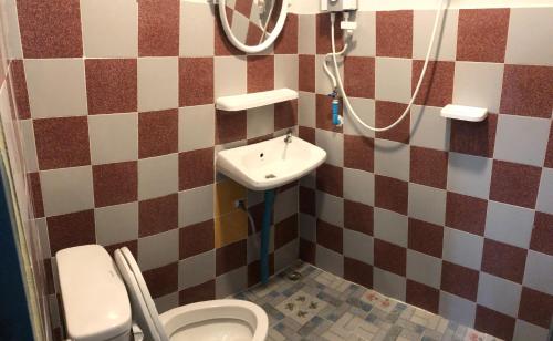 La salle de bains est pourvue de toilettes et d'un lavabo. dans l'établissement Baan Suan BBQ and Resort ชั้น2ห้อง9สองเตียง, à Khon Kaen
