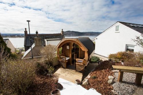 a house with a wooden archway in a yard at Fishermans in Inverness