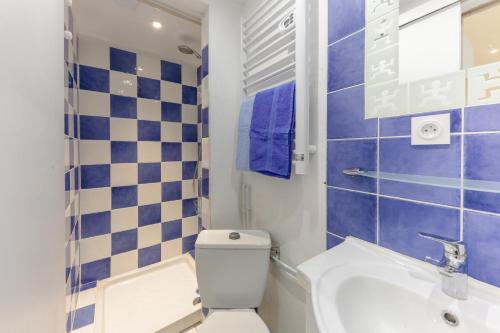 une salle de bain bleue et blanche avec des toilettes et un lavabo dans l'établissement Kerael, à Perros-Guirec