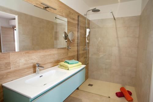 a bathroom with a sink and a shower at Les Villas de la Résidence U Veniqui in Favone
