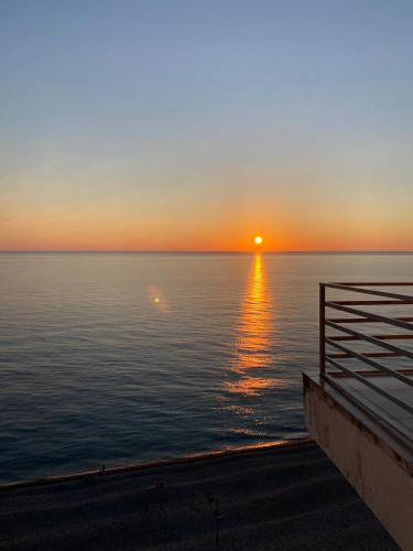 a sunset over the ocean with the sun setting at GONIO apartment in Gonio