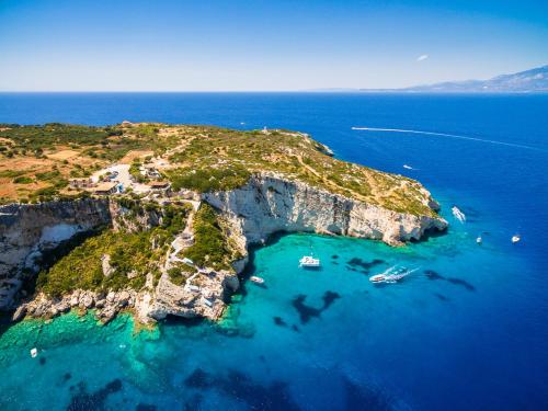 an island in the ocean with boats in the water at Potamitis Windmills & Apartments - Unique Stay with Scenic Views, by ZanteWize in Koríthion