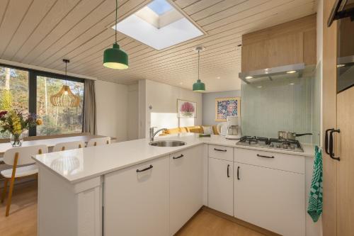 a kitchen with white cabinets and a sink at Center Parcs Bispinger Lüneburger Heide in Bispingen