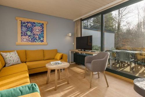 a living room with a couch and a television at Center Parcs Bispinger Lüneburger Heide in Bispingen