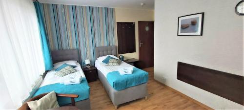a room with two beds in a hotel room at Villa Magna in Gdynia