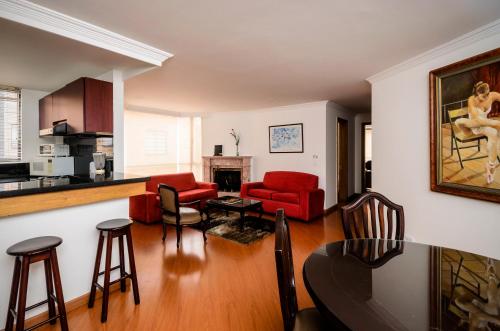 波哥大的住宿－噴泉廣場旅行者酒店，一间带红色家具的客厅和一间厨房