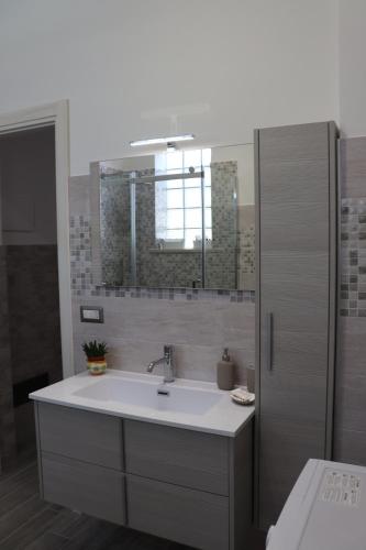 ein Bad mit einem Waschbecken und einem Spiegel in der Unterkunft Roccia Bianca in Syrakus