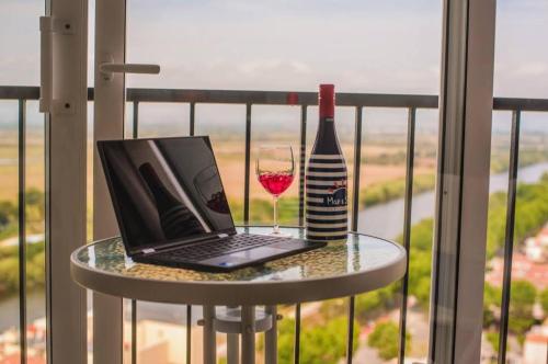 - un ordinateur portable et un verre de vin sur une table sur un balcon dans l'établissement Spondylus II, à Empuriabrava
