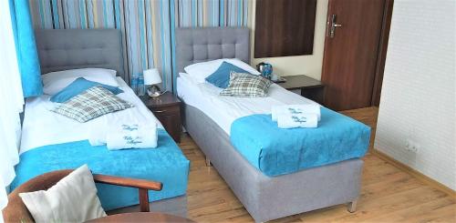 two beds in a room with blue and white at Villa Magna in Gdynia