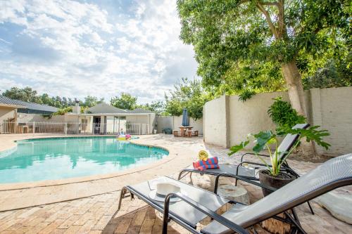 a swimming pool with a toy doll sitting on a chair next to it at Hoogwater Farmhouse in Wolseley