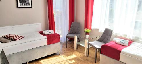 a bedroom with two beds and a table and chairs at Villa Magna in Gdynia