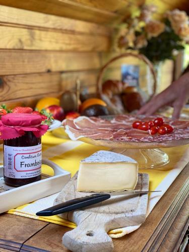 a table with cheese and other foods on it at Hôtel de famille L.F.M.A.L. in Giat