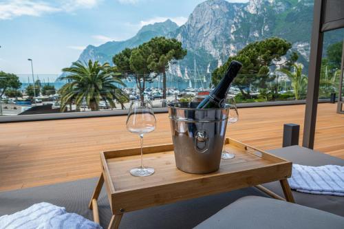a bucket with a bottle of wine and a wine glass at Lake Front Hotel Mirage in Riva del Garda