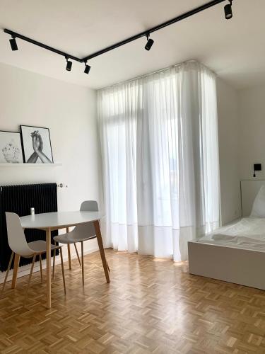 Schlafzimmer mit einem Bett, einem Tisch und Stühlen in der Unterkunft Appartement 509 in Klagenfurt am Wörthersee