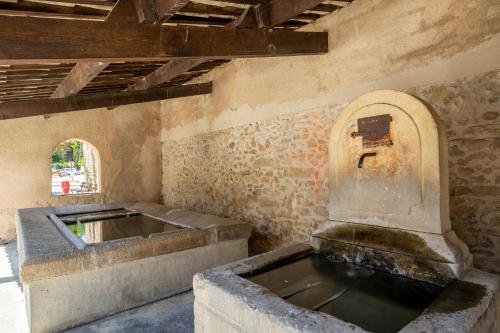 a water fountain in a room with a sink at Maison Ventoux 1 Luxe Calme Central Linge fourni in Malaucène