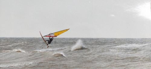 a person is windsurfing in the ocean at Heron apartments in Lido di Jesolo