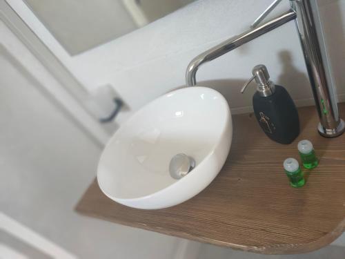 a white sink on a wooden shelf in a bathroom at Locanda mami in Aosta