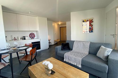 un salon avec un canapé et une table dans l'établissement Le Triangle d'Or - 1 bedroom apartment with terrace, à Annecy