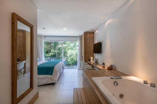 a bathroom with a bed and a bath tub and a bedroom at Live Hotel Boutique (Adults only) in Punta del Este