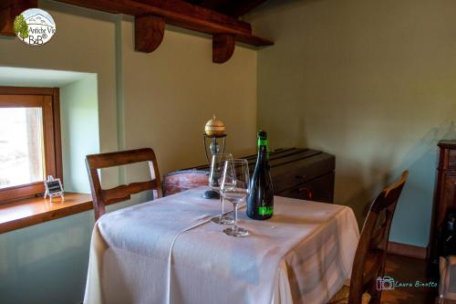 a table with a bottle of wine and glasses on it at Antiche Vie B&B in Serramazzoni