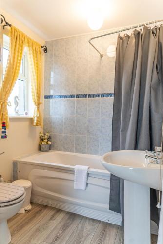 a bathroom with a tub and a sink and a toilet at The Hawthorns, Buncrana by Wild Atlantic Wanderer in Buncrana