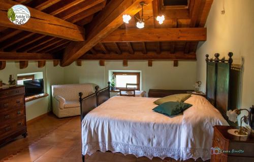 una camera con un grande letto in una stanza con soffitti in legno di Antiche Vie B&B a Serramazzoni