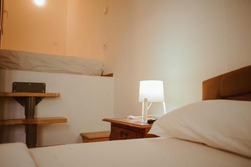 a bedroom with a bed and a lamp on a night stand at Perla Apartments in Poreč