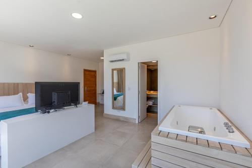 a large bathroom with a tub and a tv in it at Live Hotel Boutique (Adults only) in Punta del Este