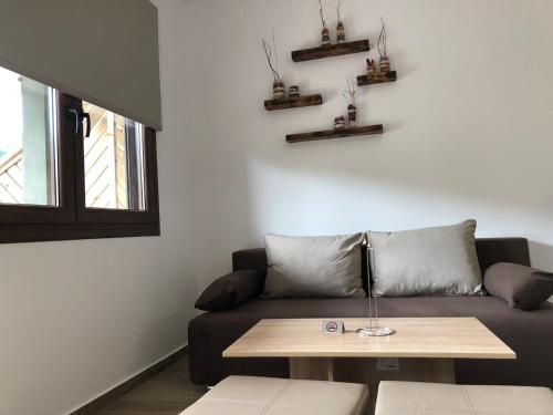 a living room with a couch and a table at MAD'S Villas in Néa Péramos