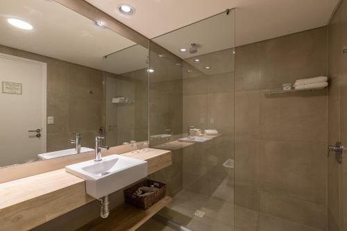 a bathroom with a sink and a shower and a mirror at Live Hotel Boutique (Adults only) in Punta del Este