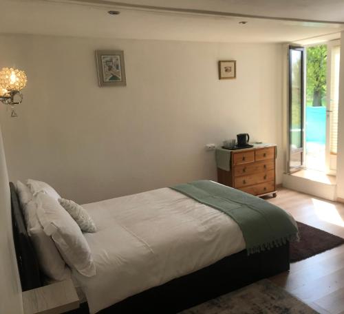 een slaapkamer met een bed, een dressoir en een raam bij Lac du logerie in La Puye