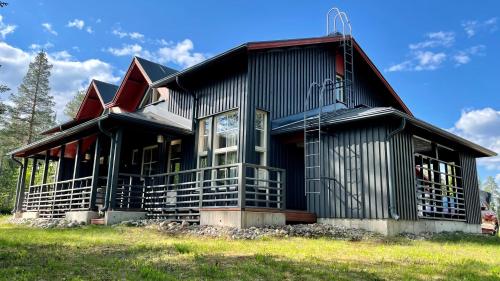 una casa negra con techo de gambrel en Tähtisara, en Syöte