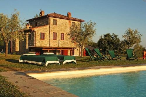 una casa con sillas verdes junto a una piscina en Villa Altomonte, en Marlia
