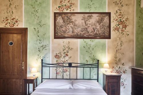 1 dormitorio con 1 cama con una pintura en la pared en Casalta Boutique Hotel, en Monteriggioni