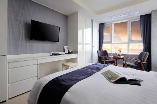 a bedroom with a bed and a tv on a wall at Ever8 Serviced Residence in Seoul