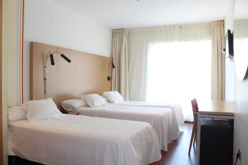 A bed or beds in a room at Hotel Ril