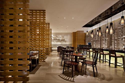 a restaurant with tables and chairs in a room at Wanda Realm Harbin Hotel in Harbin