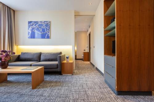 a living room with a couch and a tv at Pullman Eindhoven Cocagne in Eindhoven