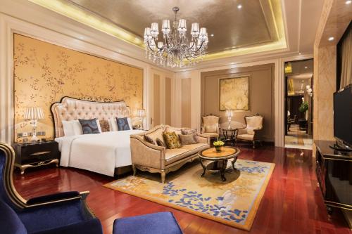 a bedroom with a bed and a chandelier at Wanda Realm Harbin Hotel in Harbin