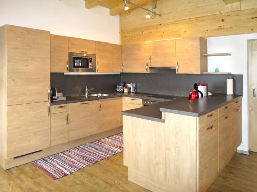 a kitchen with wooden cabinets and a counter top at Apartment Hinterkerschbaum - BRG109 by Interhome in Taxenbach