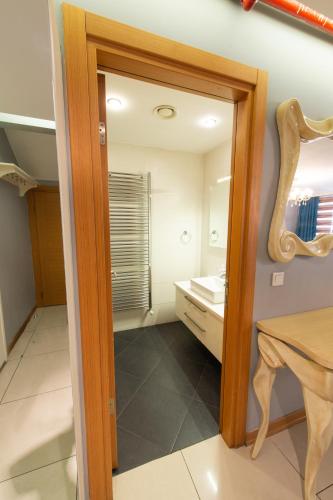 a bathroom with a mirror and a table and a sink at CTS Elysium Residence Taksim in Istanbul