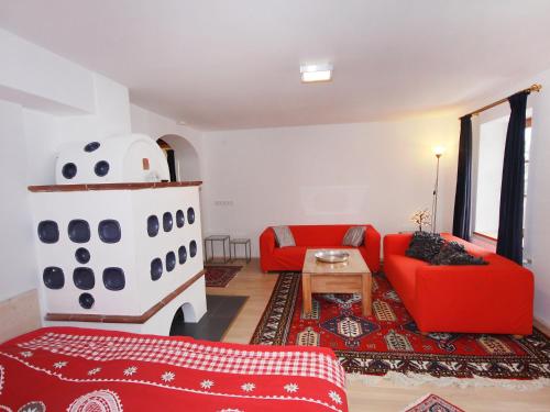 ein Wohnzimmer mit einem roten Sofa und einem Herd in der Unterkunft Chalet Ferienhaus Dr-Steiner by Interhome in Zell am See